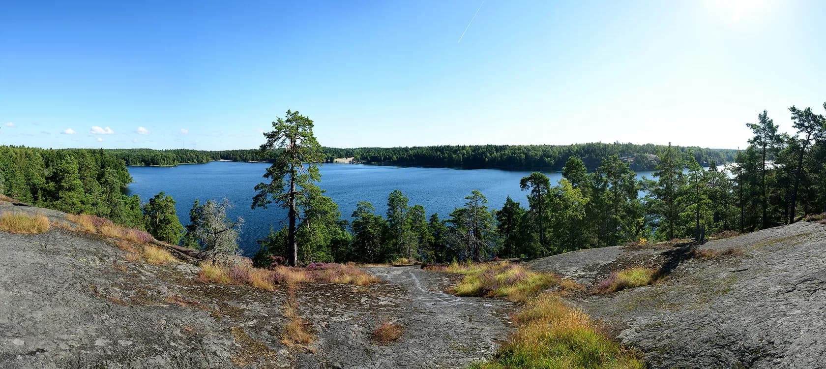 Granite cliffs and pine trees above the lake at Flaten nature reserve
